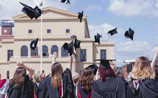 An image of graduates throwing their mortar boards in the air at winter graduation 