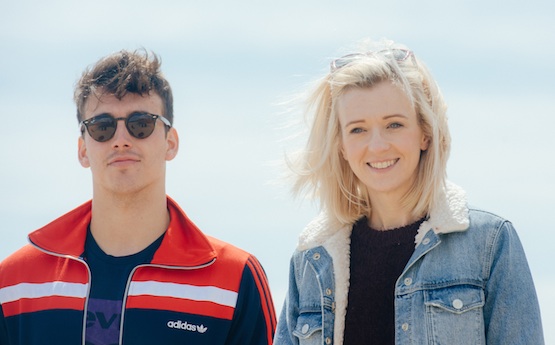 Two students walking on the beach in Swansea