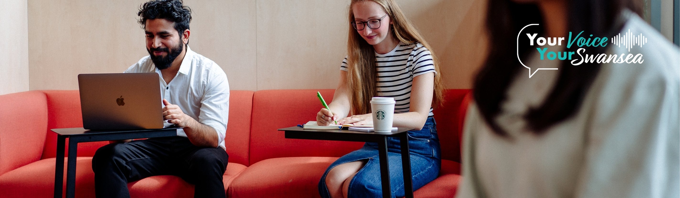 Myfyrwyr yn gweithio ar liniaduron ac yn ysgrifennu nodiadau