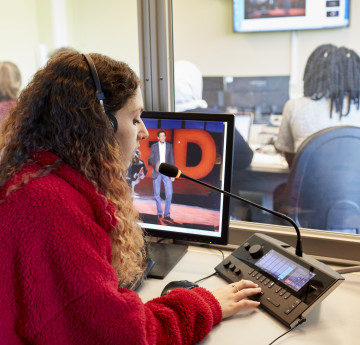 Myfyriwr yn gweithio yn y Cyfryngau