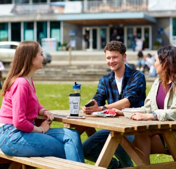 Group of students sitting on Fulton lawn chatting 