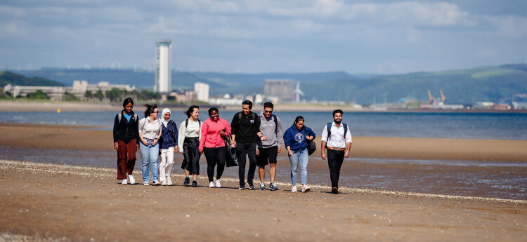 Students walking on Swansea beach