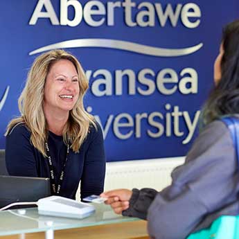 Female customer services staff talking to a female student