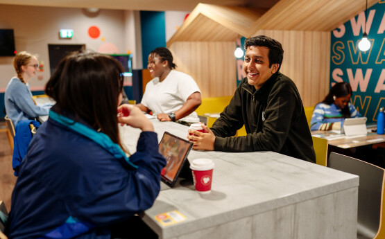 Two students chatting in a cafe over a coffee